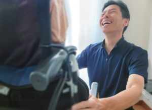 車いすの人に話しかける笑顔の男性